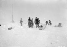 [Inuit with sleds at a Hudson's Bay Company flag pole on an island in Baker Lake] Original title: Native sleds at Hudson's Bay Company flag pole. Island in Baker Lake 1926