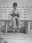 Métis boy with a bottle of ginger ale at Fort Norman, Northwest Territories July 1930.