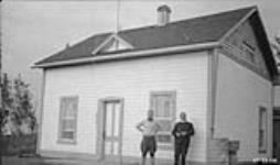 Rev. Cannon Hester and Rev. Mccallum in front of Church of England Mission house at Aklavik 1925