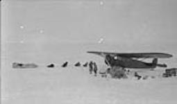 A contrast in modes of Arctic travel; Mat Berry's aeroplane and Dick Finnie's dog team April 1931