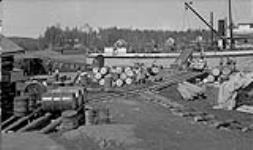 N.T. Co. freight boat unloading at Narrows, Yellowknife., Narrow gauge track by Thibert (merchant post master) June 1938.