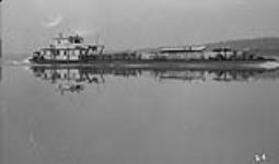 Northern Transportation Co. Sternwheeler with oil barge en route up Bear River 1942