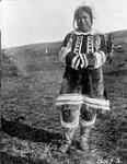 Native woman, Pond Inlet, Baffin Island, N.W.T. [(Mittimatalik/Tununiq), Nunavut], 1923. [Miali Aarjuaq wearing an "amauti" (a woman's hooded caribou parka). This photograph was taken near the R.C.M.P Detachment.] 1923.