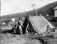 [Inuk woman with dogs next to a topek] Original title: Native topek [ca 1923]