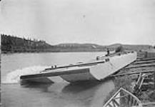 Launch of hull of first dredge ["Golden Crown No. 1"] for Stewart River at Whitehorse, Y.T., July 31, 1902 July 1902.