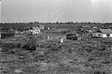 [Dene cabins on edge of Hay River settlement] Original title: Indian cabins on edge of settlement 1945