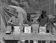 Sealing tins of biscuit to ensure keeping 1924