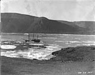 View looking northwest, showing site of Royal Canadian Mounted Police (R.C.M.P.) storehouse in foreground and C.G.S. ARCTIC at anchor in background 26 August 1924.