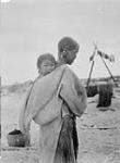 An Inuit woman carrying a small child on her back 1929