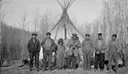 [Family of First Nation trappers with their mother in front of a teepee] Original title: Indian teepee located at Big Slough. The old lady is the mother of these trappers 1934