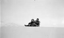 [Priscilla and Rosslyn Orford, (daughters of Dr. T.J. Orford) and an Inuk girl named Mary on a snow bank slide] Original title: Priscilla and Rosslyn Orford, (daughters of Dr. T.J. Orford) and Mary a native girl on a snow bank slide 1930