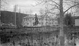 High water level mark on tree in foreground. Administration building in rear 10 May 1944.