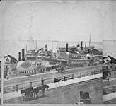 Wharves at Montreal with steamers and bridge in distance 1865