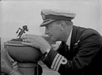 Commander E.R. Mainguy, Commanding Officer, H.M.C.S. "Ottawa", taking a bearing off Botwood, Nfld 22 June 1940