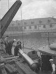 Personnel handling torpedo in H.M.C. Dockyard 19 Aug. 1940