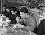 Unidentified ratings eating a meal aboard H.M.C.S ST CROIX at sea, March 1941 March 1941.