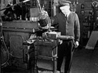 Machinist operating a milling machine in the Electrical Artificers' Workshop, H.M.C. Dockyard, Halifax, Nova Scotia, Canada, 18 November 1942 November 18, 1942.