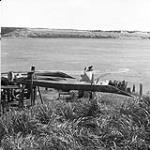 An Inuit kayak with a flat bottom. The Norseman aircraft is in the background 1949