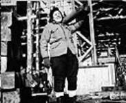 Mme Sarah Korolski transportant un tuyau au chantier naval Pictou Shipyards Ltd Jan. 1943