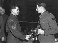Brigadier J.D.B. Smith (right) presenting a boxing trophy to Sergeant George Nyberg of the Lake Superior Regiment. England, 21 January 1944 January 21, 1944