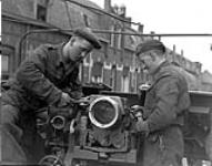 Gunner A.K. Banks and Sergeant J.T. Wettlaufer overhauling a Sexton self-propelled gun of the 19th Field Battery, Royal Canadian Artillery (R.C.A.), Tilburg, Netherlands, 17 March 1945 Marh 17, 1945.
