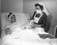Leading Seaman H.H. Nicolle, a victim of the Knights of Columbus Hostel fire, in the Royal Canadian Navy (R.C.N.) Hospital, St., John's, Newfoundland, 27 December 1942 Deember 27, 1942.