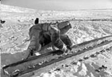 [Eskimo working on sled. Padlei, N.W.T.] [1949-50].