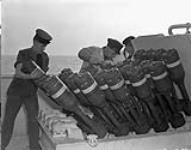 Personnel loading a Hedgehog anti-submarine mortar during trials aboard H.M.C.S. NORTH BAY, Halifax, Nova Scotia, Canada, October 1943 October, 1943.