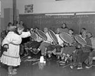 [Inuit drum dance in the Federal Day School at Aklavik, Northwest Territories] Original title: "Eskimo drum dance in the Federal Day School at Aklavik, N.W.T." [March 1956].