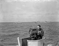 View from the corvette H.M.C.S. SHERBROOKE showing the corvette H.M.C.S. BARRIE oiling from a tanker at sea, June 1945 June 1945