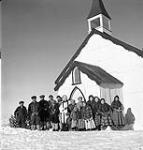 Inuit congregation with Reverend George Neilson, after morning service in the Anglican Church Jan. 1946.