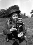 Le lieutenant Frank L. Dubervill, de l'Unité de film et de photo de l'Armée canadienne, tient un appareil-photo Anniversary Speed Graphic, Angleterre, 11 mai 1944 May 11, 1944.
