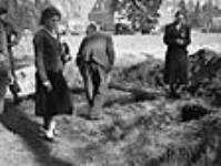 Civilians attempting to identify the bodies of people who were killed by the Gestapo on the Bolderhey estate 8 avril 1945