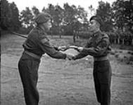 Lt. Col. D.C. Howat, Commanding Officer of the Regina Rifle Regiment presents a Commander-in-Chief certificate for gallantry to Company Quartermaster H.W. Taylor, Ede, Netherlands, 26 September 1945 September 26, 1945.