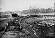 Railway cars in a lumber yard after the Hull - Ottawa Fire of 1900 [ca. April 26, 1900].