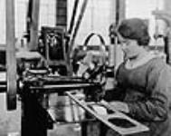 Woman sewing wire stitching of wing web reinforcement strips, Canadian Aeroplanes Ltd 1918