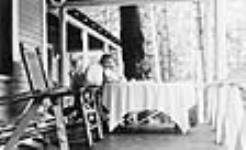 W.L. Mackenzie King at table on verandah od Kingswood Cottage 1920-1930