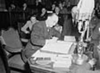 Mr. Joseph Smallwood signing the agreement which admitted Newfoundland into Confederation. Hon. A.J. Walsh, chairman of the Newfoundland delegation, is at the right 11 Dec. 1948