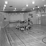 "Eskimo and Indian pupils exercise in huge gymnasium at local Federal School, Inuvik, N.W.T. [December 1959]." December 1959.