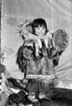 Inuit child  [Ihumatak, George Evaglok's adopted daughter, learning how to drum dance and sing. All children were taught the "pihiks" (drum dance songs).] 1949-1950