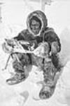 Inuit lisant le magazine " Forest and Outdoors ", Padlei, T.N.-O. [Kigusiutnak. Autrefois, il y avait très peu de magazines.] 1949-1950