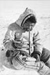 Inuit utilisant un perçoir à archet, Padlei, T.N.-O. [Pingiqayuk en train de percer un  trou. Anciennement, tous les outils étaient faits maison.] 1949-1950