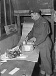 Private Leon Biron of No.1 Army Base Post Office, Canadian Postal Corps (C.P.C.), rewrapping damaged parcels, Dieppe, France, 11 October 1944 October 11, 1944.