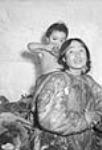 [Evano Aggark (boy) and Albina Ikertak Aggark (his mother) of Eskimo Point area in Keewatin Region, N.W.T.] [1949 or 1950]