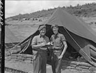 Sergeants Roy Fraser (left) and J.J. Worden checking list of R.C.R. personnel serving in Korea 12 June 1953