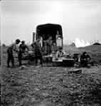 Troopers of the 12th Manitoba Dragoons outisde the regiment's mobile cookhouse near Vaucelles, France, 19 July 1944 July 19, 1944.