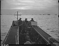 View of the quarterdeck of L.C.A. looking forward as she leaves H.M.C.S. PRINCE DAVID with soldiers from the Regiment de la Chauudiere to make assault on beachhead. Other invasion ships on the horizon 9 May 1944