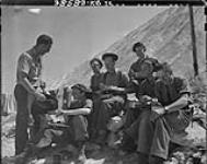 Royal Canadian Electrical and Mechanical Engineers group at lunch. Cpl. cook A.R. Rollins, D.H. Campbell, J.E. Fendly, W.A. Patterson, D.G. Spooner and L.G. Sanders 14 Aug. 1944
