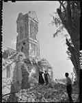 Father Le Normand showing Private J.W. Lorrain damage to church 11 Aug. 1944