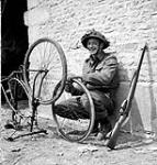 Private R.O. Potter of The Highland Light Infantry of Canada repairing his bicycle, France, 20 June 1944 June 20, 1944.
